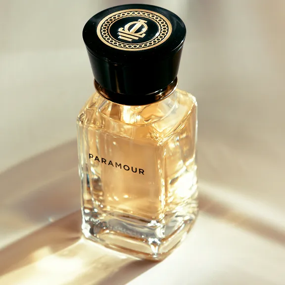 Parfümflakon PARAMOUR: bernsteinfarben, großer Verschluss im Sonnenlicht.